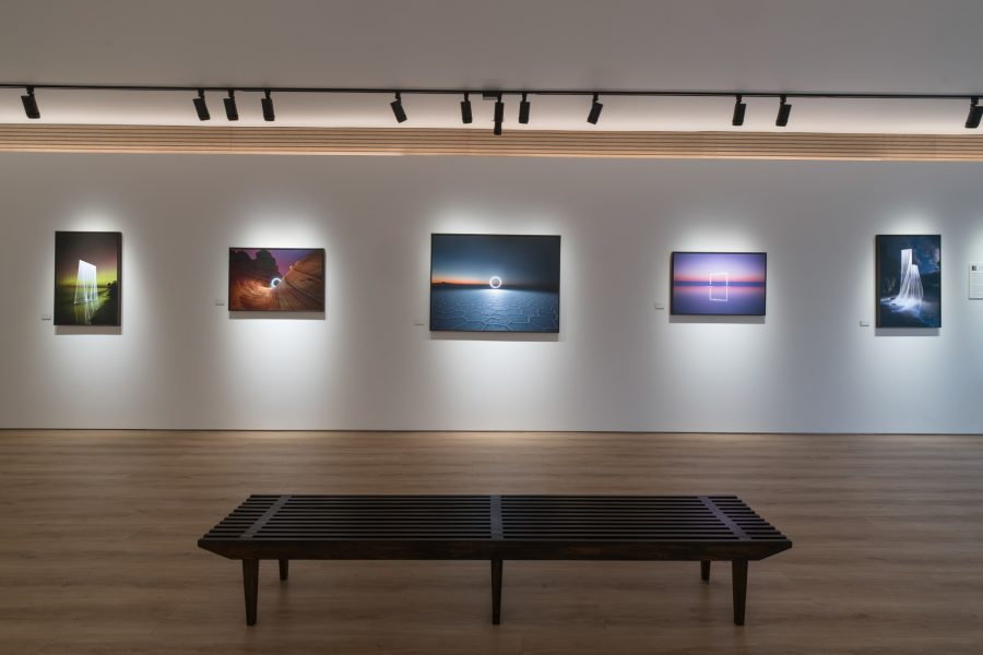 Track lighting heads washing framed artworks in a modern gallery